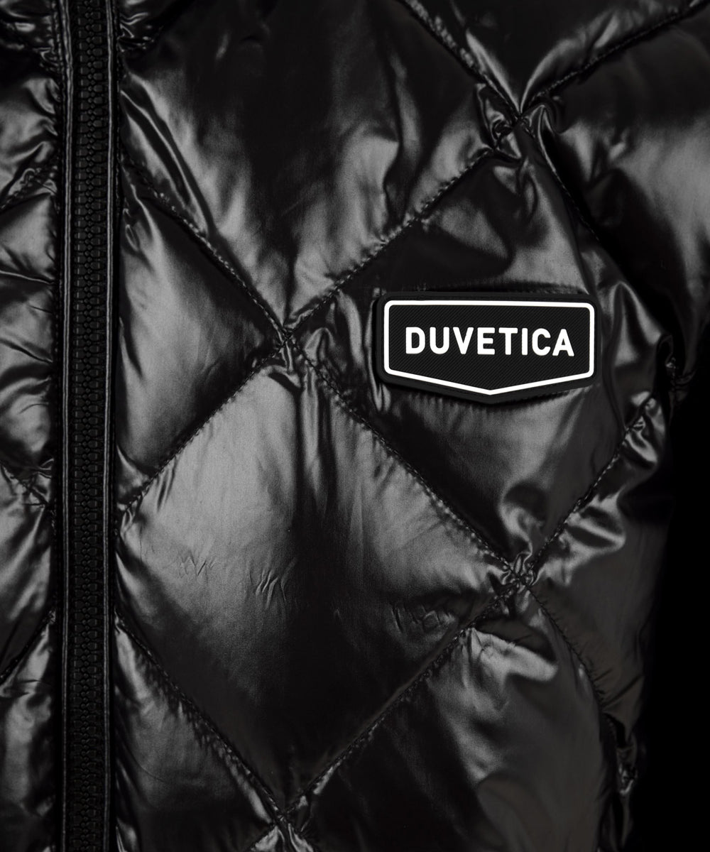 Dettaglio del patch con logo Duvetica posto sul giubbotto Cedegolo da donna firmato Duvetica