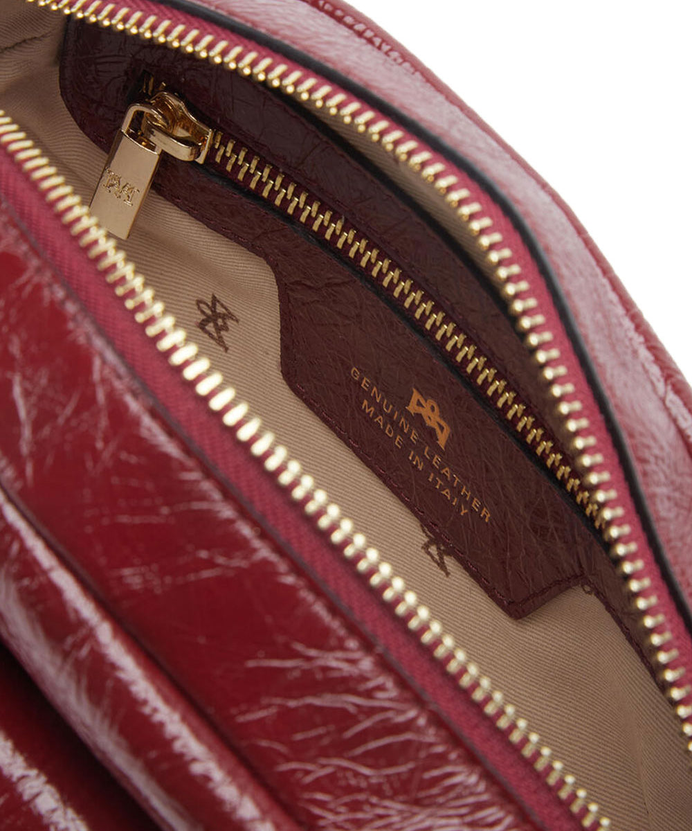 Interno della borsa rossa in pelle da donna firmata Cuoieria Fiorentina con singolo scomparto con chiusura a zip, taschino e tasca con chiusura a zip.