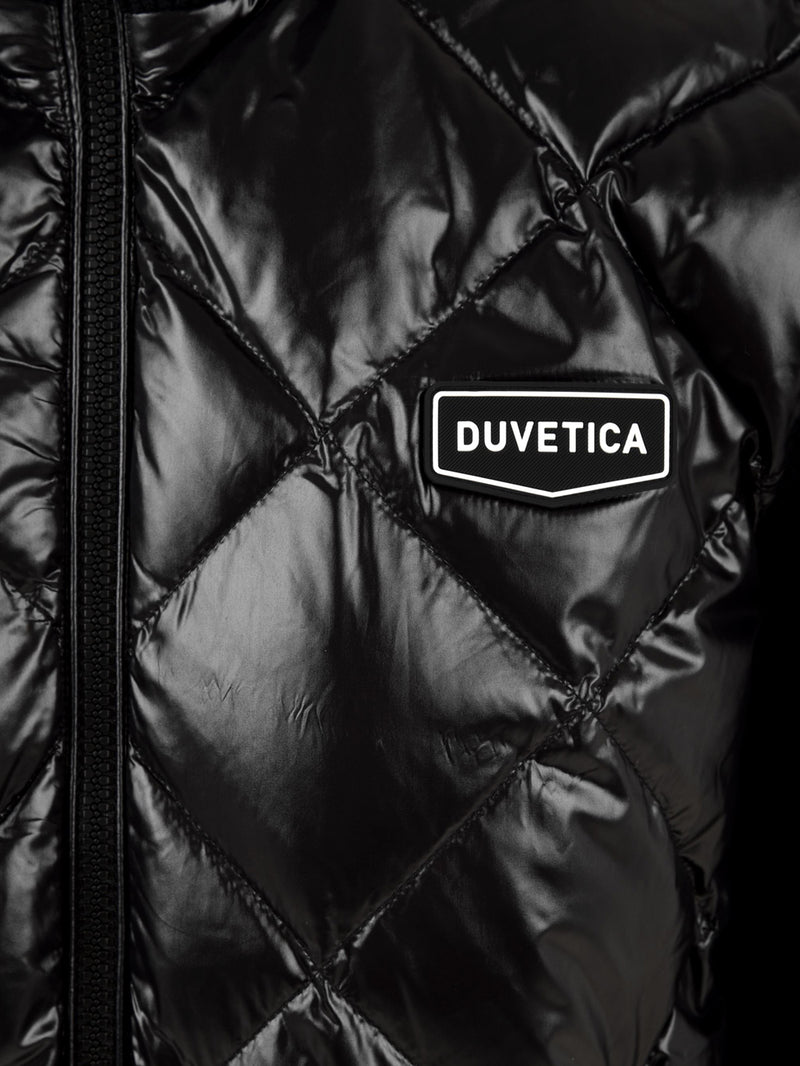 Dettaglio del patch con logo Duvetica posto sul giubbotto Cedegolo da donna firmato Duvetica